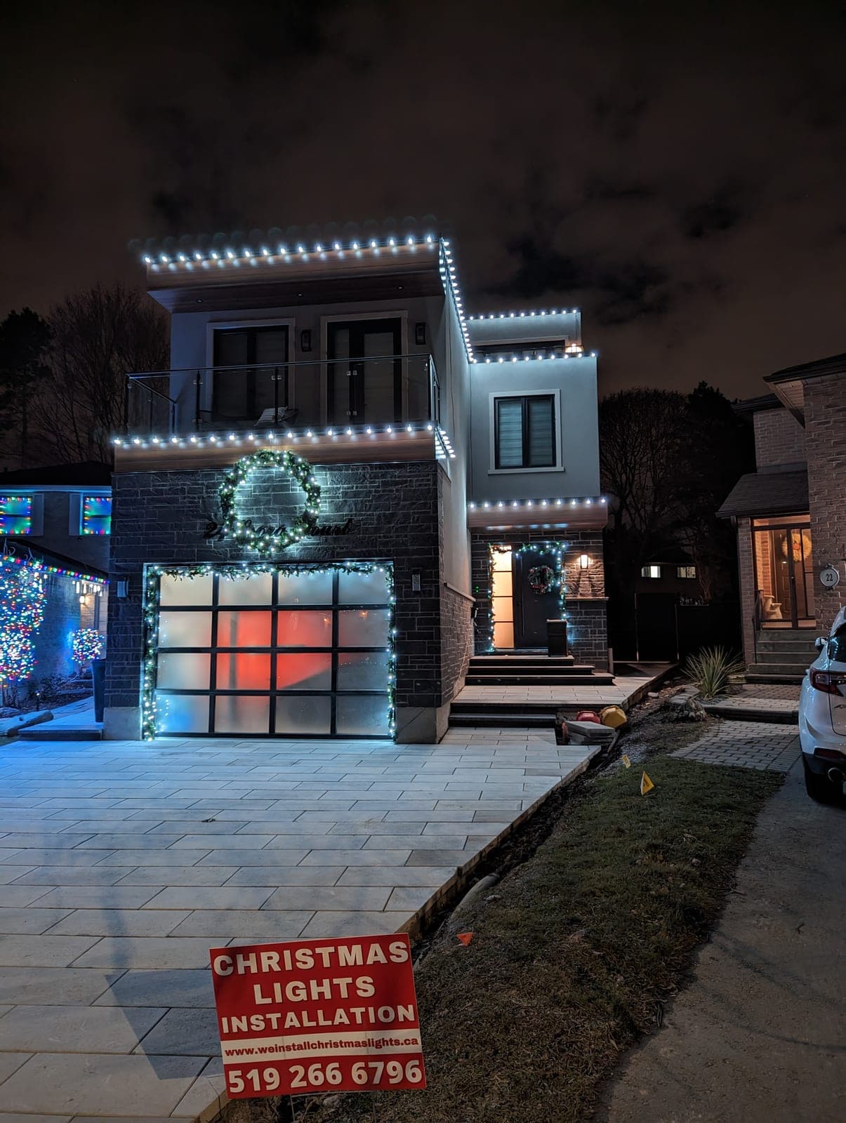 Professional warm-white Christmas light installation on a modern two-storey home